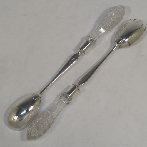 A pretty pair of Antique Victorian Sterling Silver and crystal handled salad servers, having very plain bodies with oval bowls, and hand-cut crystal handles. This beautiful antique silver and crystal salad serving set was made by Angel and Savoury of London in 1886. The length of these silver and crystal salad servers are 30.5 cms (12 inches).   