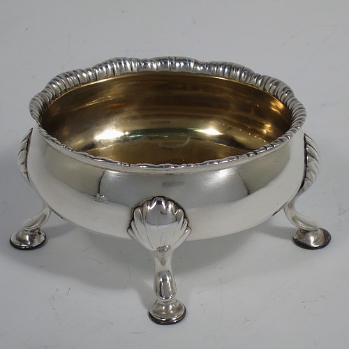 An Antique Georgian Sterling Silver pair of salt cellars, having plain oval bodies, with gold-gilt interiors, applied shaped gadroon borders, and all sitting on four cast hoof feet with shell shoulders. Made by Robert and David Hennell of London in 1767. The dimensions of these fine hand-made antique silver salt cellars are length 9 cms (3.5 inches), width 8 cms (3 inches), height 4.5 cms (1.75 inches), and they weigh a total of approx. 177g (5.7 troy ounces).   