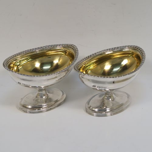 A very handsome Antique Edwardian Sterling Silver pair of salt cellars, in a boat-shaped style, having plain oval bodies, with gold-gilt interiors, applied  gadroon borders, and all sitting on oval pedestal feet. These elegant antique silver salt dishes were made by D. and J. Welby of London in 1905. The dimensions of these fine hand-made antique silver salt cellars are length 10 cms (4 inches), width 6.5 cms (2.5 inches), height 6.5 cms (2.5 inches), and they weigh a total of approx. 162g (5.2 troy ounces).   