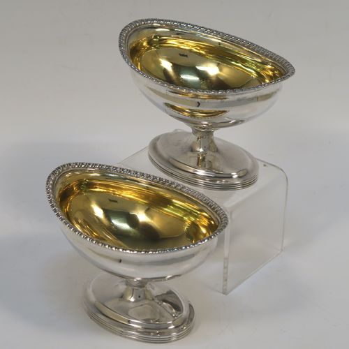 A very handsome Antique Edwardian Sterling Silver pair of salt cellars, in a boat-shaped style, having plain oval bodies, with gold-gilt interiors, applied  gadroon borders, and all sitting on oval pedestal feet. These elegant antique silver salt dishes were made by D. and J. Welby of London in 1905. The dimensions of these fine hand-made antique silver salt cellars are length 10 cms (4 inches), width 6.5 cms (2.5 inches), height 6.5 cms (2.5 inches), and they weigh a total of approx. 162g (5.2 troy ounces).   