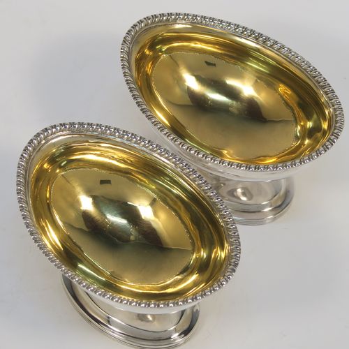 A very handsome Antique Edwardian Sterling Silver pair of salt cellars, in a boat-shaped style, having plain oval bodies, with gold-gilt interiors, applied  gadroon borders, and all sitting on oval pedestal feet. These elegant antique silver salt dishes were made by D. and J. Welby of London in 1905. The dimensions of these fine hand-made antique silver salt cellars are length 10 cms (4 inches), width 6.5 cms (2.5 inches), height 6.5 cms (2.5 inches), and they weigh a total of approx. 162g (5.2 troy ounces).   