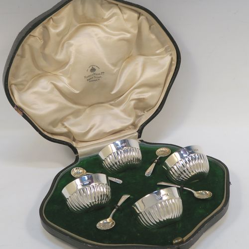 A very pretty set of four Antique Sterling Silver  salt cellars, having round bellied bodies with hand-chased half-fluted decoration, with blue glass liners, and sitting on flat bases, together with four original salt spoons, all in their cream satin and green velvet-line presentation box. These beautiful antique silver salt cellars and condiment spoons were made by Mappin and Webb of Sheffield in 1917. The dimensions of these fine hand-made antique silver salt cellars are diameter 5.5 cms (2.2 inches), height 3 cms (1.25 inches), and they weigh a total of approx. 143g (4.6 troy ounces).   