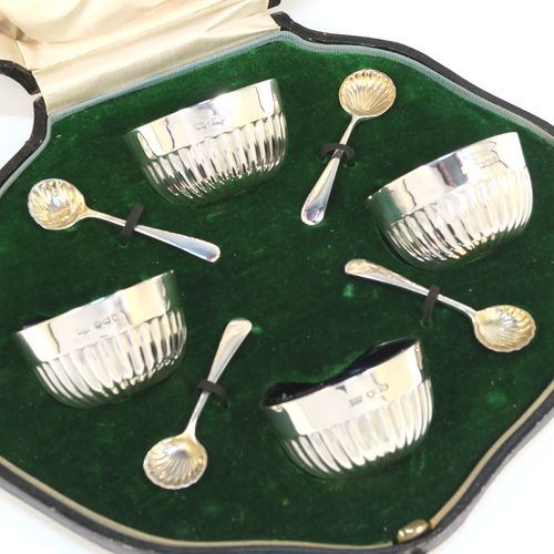 A very pretty set of four Antique Sterling Silver  salt cellars, having round bellied bodies with hand-chased half-fluted decoration, with blue glass liners, and sitting on flat bases, together with four original salt spoons, all in their cream satin and green velvet-line presentation box. These beautiful antique silver salt cellars and condiment spoons were made by Mappin and Webb of Sheffield in 1917. The dimensions of these fine hand-made antique silver salt cellars are diameter 5.5 cms (2.2 inches), height 3 cms (1.25 inches), and they weigh a total of approx. 143g (4.6 troy ounces).   