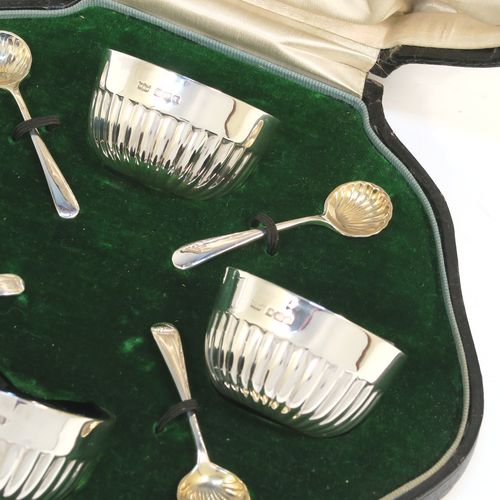 A very pretty set of four Antique Sterling Silver  salt cellars, having round bellied bodies with hand-chased half-fluted decoration, with blue glass liners, and sitting on flat bases, together with four original salt spoons, all in their cream satin and green velvet-line presentation box. These beautiful antique silver salt cellars and condiment spoons were made by Mappin and Webb of Sheffield in 1917. The dimensions of these fine hand-made antique silver salt cellars are diameter 5.5 cms (2.2 inches), height 3 cms (1.25 inches), and they weigh a total of approx. 143g (4.6 troy ounces).   