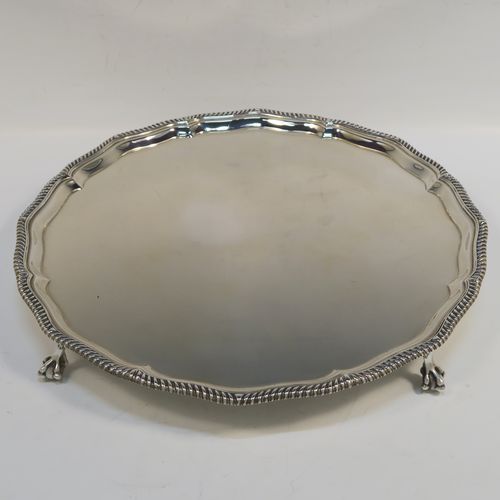 A very elegant Antique Edwardian Sterling Silver salver, having an applied Gadroon border, a plain ground, and sitting on four cast claw and ball feet. This handsome antique silver salver was made by Goldsmiths and Silversmiths of London in 1910. The dimensions of this fine hand-made silver salver are diameter 30.5 cms (12 inches), and it weighs approx. 878g (28 troy ounces).   