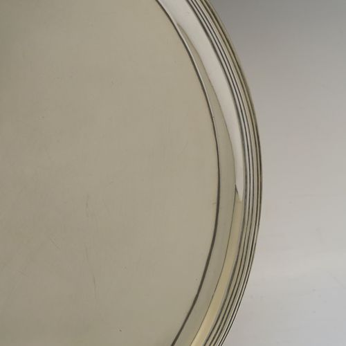 A very handsome Antique Georgian Sterling Silver salver, having an applied reeded border, a plain ground, and sitting on four cast reeded feet. This beautiful antique silver salver was made by John Hutson of London in 1792. The dimensions of this fine hand-made antique silver salver are diameter 35.5 cms (14 inches), and it weighs approx. 1,214g (39 troy ounces).  