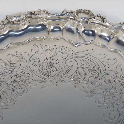 A beautiful Antique early Victorian Sterling Silver salver, having an applied cast shell and scroll border, the ground having hand-chased floral and scroll decoration surrounding a central vacant cartouche, and all sitting on three cast and pierced scroll feet. This fantastic salver was made by the most important 19th century British silversmith Paul Storr of London in 1838. The dimensions of this fine hand-made antique silver salver are diameter 32 cms (12.3 inches), height 4 cms (1.5 inches), and it weighs approx. 1,006g (32.5 troy ounces).   