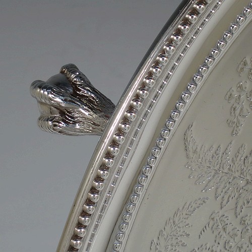 A very pretty Antique Victorian Sterling Silver large salver, having an applied double bead-edged border, with a ground having hand-engraved ferns and song-bird decoration surrounding a central vacant round cartouche, and all sitting on four cast claw and ball feet. Made by Johnson, Walker, and Tolhurst of London in 1881. The dimensions of this fine hand-made antique silver salver are diameter 38 cms (15 inches), and it weighs approx. 1,615g (52 troy ounces).   