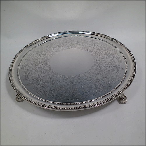 A very pretty Antique Victorian Sterling Silver large salver, having an applied double bead-edged border, with a ground having hand-engraved ferns and song-bird decoration surrounding a central vacant round cartouche, and all sitting on four cast claw and ball feet. Made by Johnson, Walker, and Tolhurst of London in 1881. The dimensions of this fine hand-made antique silver salver are diameter 38 cms (15 inches), and it weighs approx. 1,615g (52 troy ounces).   