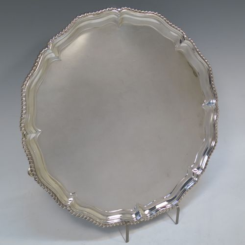 A very handsome Antique Edwardian Sterling Silver salver, having an applied shaped gadroon border, a plain ground, and sitting on three cast hoof feet. This elegant antique silver salver was made in London in 1904. The dimensions of this fine hand-made antique silver salver are diameter 33 cms (13 inches), and it weighs approx. 1,140g (37 troy ounces).   