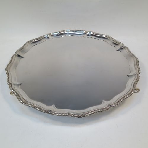 A very handsome Antique Edwardian Sterling Silver salver, having an applied shaped gadroon border, a plain ground, and sitting on three cast hoof feet. This elegant antique silver salver was made in London in 1904. The dimensions of this fine hand-made antique silver salver are diameter 33 cms (13 inches), and it weighs approx. 1,140g (37 troy ounces).   