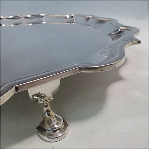 A large Antique Sterling Silver salver, having a round body, with a plain burnished ground, an applied Bath border, and sitting on four cast hoof feet. Made by Carrington and Co., of London in 1915. The dimensions of this fine hand-made antique silver salver are diameter 46 cms (18 inches), and it weighs approx. 2,388g (77 troy ounces).    