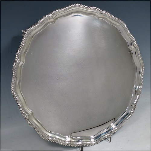 A large Sterling Silver salver, having a round body, with a plain burnished ground, an applied Shaped Gadroon border, and sitting on four cast claw and ball feet. Made by Thomas Bradbury & Sons of Sheffield in 1945. The dimensions of this fine hand-made silver salver are diameter 36 cms (14.25 inches), and it weighs approx. 1,333g (43 troy ounces).    