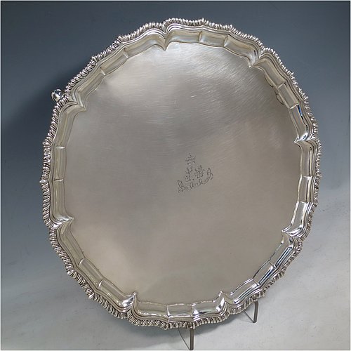 A very handsome Antique Georgian Irish Sterling Silver salver, having an applied shaped gadroon border, a plain ground with a hand-engraved armorial central crest and Latin motto, and sitting on four cast hoof feet. This elegant Irish antique silver salver was made in Dublin, Ireland, in 1796. The dimensions of this fine hand-made antique silver salver are diameter 36 cms (14.25 inches), and it weighs approx. 1,190g (38 troy ounces).    