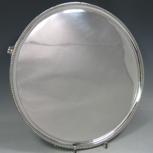 Antique Georgian sterling silver salver, having an applied bead border, plain ground, and sitting on four flange feet with bead edges. Made by Elizabeth Jones of London in 1790. Diameter 36 cms (14 inches). Weight approx. 1,248g (40.3 troy ounces).