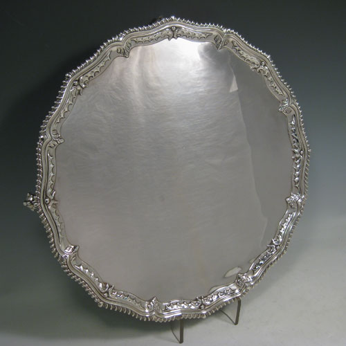 A handsome Antique Georgian Sterling Silver salver, having an applied shaped gadroon border with hand-chased anthemion leaves, a plain ground, and sitting on four cast claw and ball feet. This beautiful antique salver was made by Richard Rugg of London in 1768. The dimensions of this fine hand-made silver slaver are diameter 38 cms (15 inches), and it weighs approx. 1,368g (44 troy ounces).   