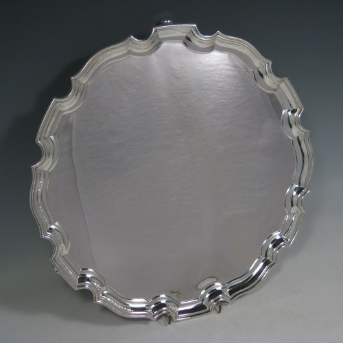    Sterling silver large salver, having a Chippendale border, plain ground, and sitting on three cast scroll feet. Made by the Adie Brothers of Birmingham in 1927. Diameter 36 cms (14 inches). Weight approx. 1,270g (41 troy ounces).