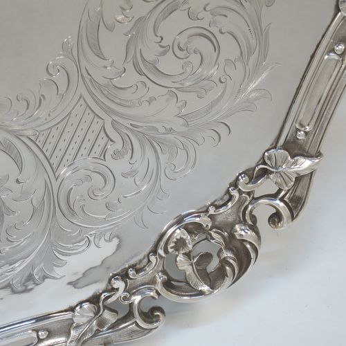 A very pretty Antique Victorian Silver Plated large salver, having an applied cast scroll border with floral decoration and piercing, with a ground having hand-engraved floral and scroll decoration surrounding a central vacant round cartouche, and all sitting on three cast scroll  feet. Made (poss.) by James Dixon And Sons of Sheffield in ca. 1860. The dimensions of this fine hand-made antique silver-plated salver are diameter 48 cms (19 inches), and height 5 cms (2 inches).  