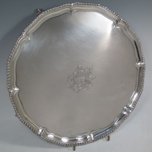 A very handsome Antique Georgian Sterling Silver salver, having an applied shaped gadroon border, a plain ground with a hand-engraved armorial central crest, and sitting on four cast claw and ball feet. This beautiful antique silver salver was made by John Carter II of London in 1772. The dimensions of this fine hand-made antique silver salver are diameter 35 cms (13.75 inches), and it weighs approx. 1,270g (41 troy ounces).    