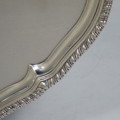 A very handsome Antique Georgian Sterling Silver salver, having an applied shaped gadroon border, a plain ground with a hand-engraved armorial central crest, and sitting on four cast claw and ball feet. This beautiful antique silver salver was made by John Carter II of London in 1772. The dimensions of this fine hand-made antique silver salver are diameter 35 cms (13.75 inches), and it weighs approx. 1,270g (41 troy ounces).    