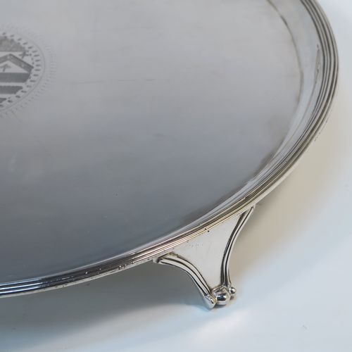 A large and very handsome Antique Georgian Sterling Silver salver, having a round body with an applied reeded border, a plain ground with a hand-engraved full armorial central crest, and sitting on four cast reeded and flanged feet. This elegant antique silver salver was made by Charles Hougham of London in 1790. The dimensions of this fine hand-made antique silver salver are diameter 38 cms (15 inches), and it weighs approx. 1,440g (46.5 troy ounces).   