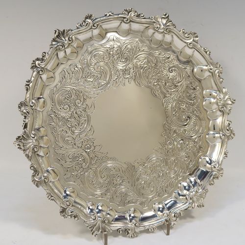 A beautiful Antique Georgian (William IV) Sterling Silver salver, having a hand-chased ground with floral and scroll decoration, an applied cast shell and scroll border and sitting on three cast foliate  feet. This pretty antique silver salver was made by the Barnard Brothers of London in 1835. The dimensions of this fine hand-made silver salver are diameter 24 cms (9.5 inches), and it weighs approx. 478g (15.4 troy ounces).  