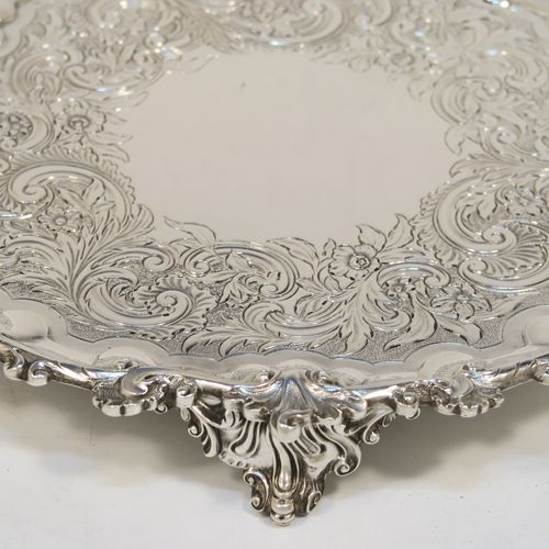 A beautiful Antique Georgian (William IV) Sterling Silver salver, having a hand-chased ground with floral and scroll decoration, an applied cast shell and scroll border and sitting on three cast foliate  feet. This pretty antique silver salver was made by the Barnard Brothers of London in 1835. The dimensions of this fine hand-made silver salver are diameter 24 cms (9.5 inches), and it weighs approx. 478g (15.4 troy ounces).  