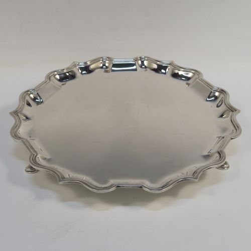 A very handsome Antique Edwardian Scottish Sterling Silver salver, having a round body, with a plain burnished ground, an applied Bath edged border, and sitting on three cast hoof feet. This elegant silver salver was made by Brook and Son of Edinburgh in 1904. The dimensions of this fine hand-made antique silver salver are diameter 26 cms (10.25 inches), and it weighs approx. 555g (18 troy ounces).   