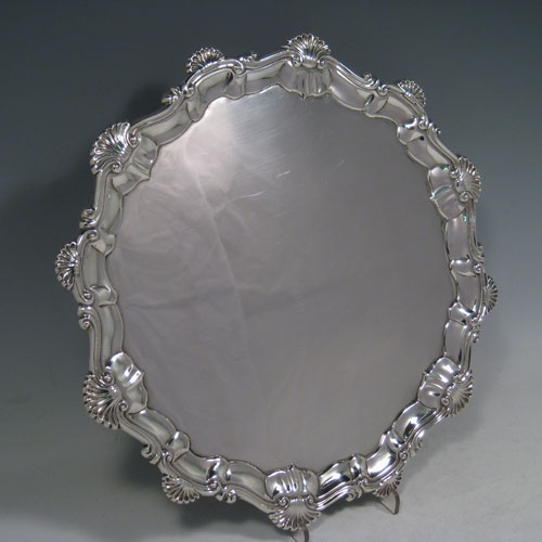 Antique Georgian sterling silver salver, having a shell and scroll border, a plain ground, and sitting on three cast hoof feet. Made by Ebenezer Coker of London in 1768. The dimensions of this fine hand-made silver salver are diameter 29 cms (11.5 inches), and it weighs approx. 688g (22 troy ounces).   