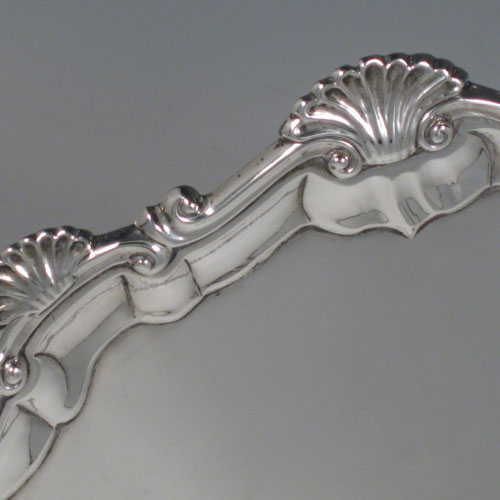 Antique Georgian sterling silver salver, having a shell and scroll border, a plain ground, and sitting on three cast hoof feet. Made by Ebenezer Coker of London in 1768. The dimensions of this fine hand-made silver salver are diameter 29 cms (11.5 inches), and it weighs approx. 688g (22 troy ounces).   