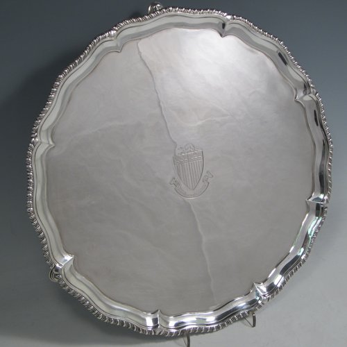 Antique Georgian sterling silver salver, having a shaped gadroon border, a plain ground with a centrally engraved armorial crest, and sitting on three cast hoof feet. Made by Richard Rugg of London in 1770. The dimensions of this fine hand-made silver salver are diameter 30 cms (12 inches), and it weighs approx. 784g (25 troy ounces).   