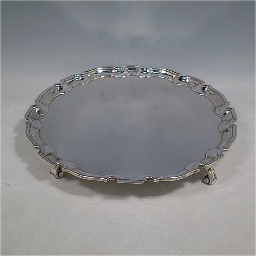 An Antique Georgian Sterling Silver George II salver, having a Chippendale border, a plain ground, and sitting on four cast scroll feet. Made by John Tuite of London in 1730. The dimensions of this fine hand-made antique silver salver are diameter 26.5 cms (10.25 inches), and it weighs approx. 491g (15.8 troy ounces).    