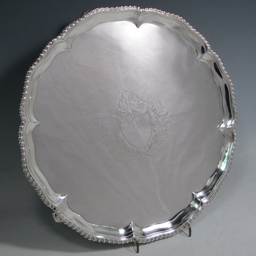 Antique Georgian sterling silver salver, having a shaped gadroon border, a plain ground with a centrally engraved armorial crest, and sitting on three cast hoof feet. Made by Richard Rugg of London in 1773. The dimensions of this fine hand-made silver salver are diameter 27.5 cms (10.75 inches), and it weighs approx. 685g (22 troy ounces).   