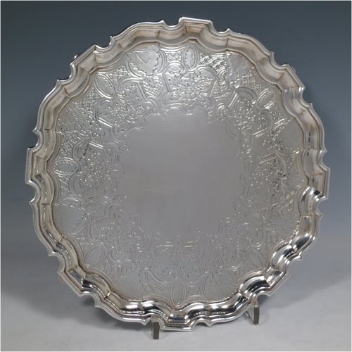 An Antique Georgian Sterling Silver salver, having an applied Chippendale border, a hand-chased ground with floral decoration, and sitting on four cast hoof feet. Made by George Hindmarsh of London in 1738. The dimensions of this fine hand-made silver salver are diameter 25 cms (10 inches), and it weighs approx. 594g (19.2 troy ounces).   