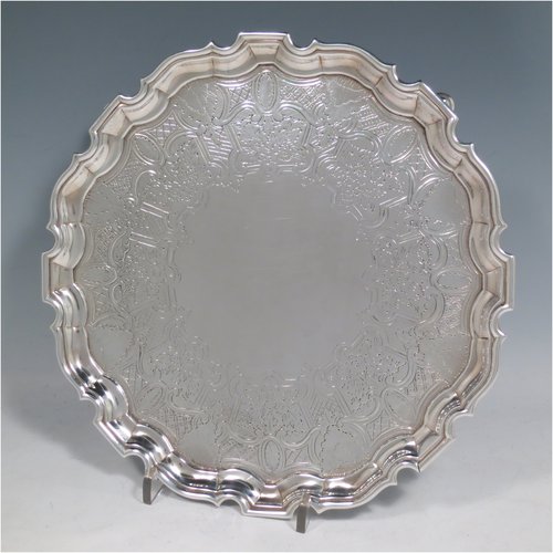 An Antique Georgian Sterling Silver salver, having an applied Chippendale border, a hand-chased ground with floral decoration, and sitting on four cast hoof feet. Made by George Hindmarsh of London in 1738. The dimensions of this fine hand-made silver salver are diameter 25 cms (10 inches), and it weighs approx. 594g (19.2 troy ounces).   