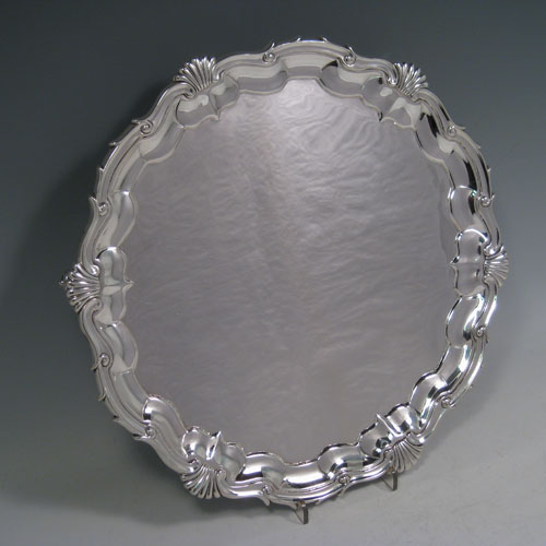 A very elegant Antique Victorian Sterling Silver salver, having an applied shell and scroll border, a plain ground, and sitting on three cast scroll feet. Made in London in 1840. The dimensions of this fine hand-made antique silver salver are diameter 29.5 cms (11.5 inches), height 3.5 cms (1.3 inches), and it weighs approx. 850g (27 troy ounces)