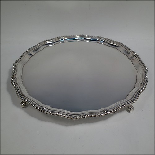 A very handsome Sterling Silver salver, having a round body, with a plain burnished ground, an applied shaped gadroon border, and sitting on four cast claw and ball feet. Made by the Barker Brothers of Birmingham in 1937. The dimensions of this fine hand-made silver salver are diameter 31 cms (12.25 inches), and it weighs approx. 1,040g (33.5 troy ounces).    