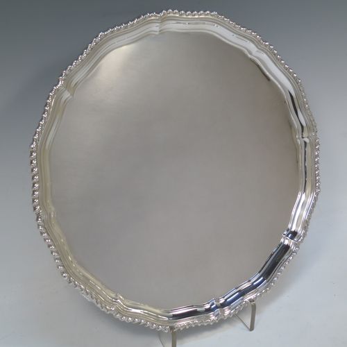 A very handsome Sterling Silver salver, having an applied shaped gadroon border, a plain ground, and sitting on three cast scroll feet. Made by I.S. Greenberg of Birmingham in 1929. The dimensions of this fine hand-made silver salver are diameter 30.5 cms (12 inches), and it weighs approx. 990g (32 troy ounces).   