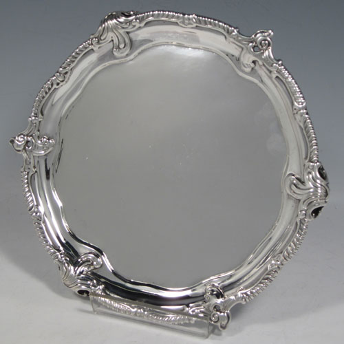 Antique Georgian sterling silver pair of George III salvers, having plain grounds, cast applied shaped gadroon and floral borders, and sitting on three cast and pierced foliate feet. Made by John Harvery I (possibly) of London in 1763 <a href=http://en.wikipedia.org/wiki/1763>(see what happened in this year).</a> The dimensions of these fine hand-made silver salvers are diameter 21 cms (8.25 inches), and they weigh approx. 789g (25.5 troy ounces).