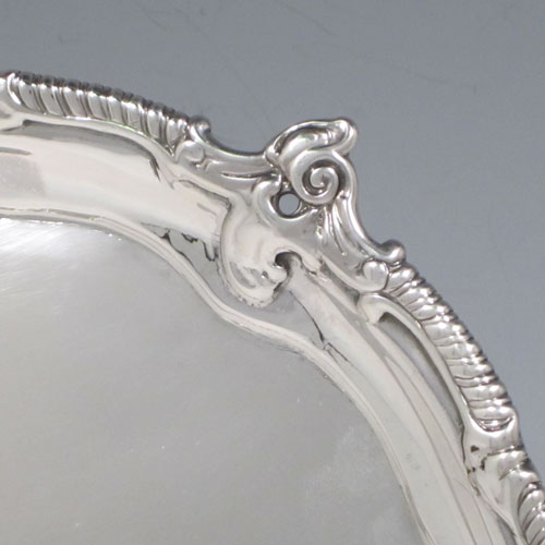 Antique Georgian sterling silver pair of George III salvers, having plain grounds, cast applied shaped gadroon and floral borders, and sitting on three cast and pierced foliate feet. Made by John Harvery I (possibly) of London in 1763 <a href=http://en.wikipedia.org/wiki/1763>(see what happened in this year).</a> The dimensions of these fine hand-made silver salvers are diameter 21 cms (8.25 inches), and they weigh approx. 789g (25.5 troy ounces).