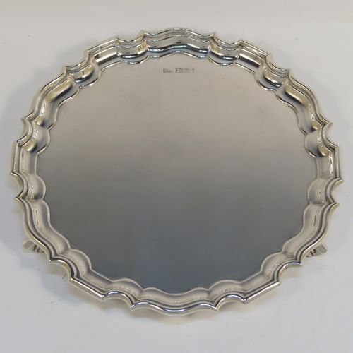 A handsome Antique Sterling Silver round salver, having a plain burnished ground, an applied Chippendale border, and sitting on three cast scroll feet. This elegant silver salver was made by Walker and Hall of Sheffield in 1924. The dimensions of this fine hand-made antique silver salver are diameter 20 cms (8 inches), and it weighs approx. 319g (10.3 troy ounces).  