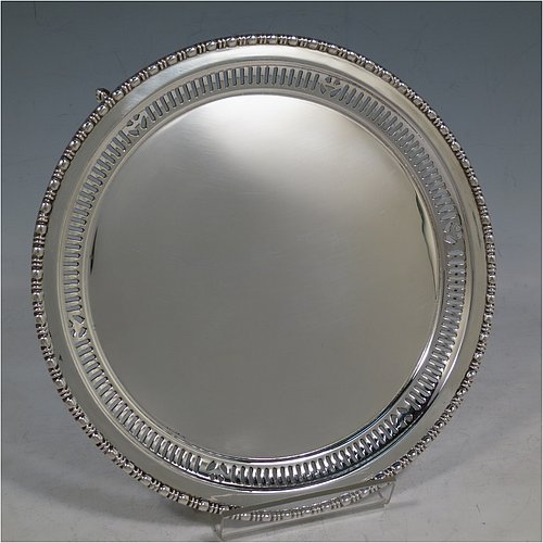 An Antique Sterling Silver salver, having a plain ground, with an applied egg & dart border above a band of hand-pierced geometrical decoration, and all sitting on three cast and scroll feet. Made by the Barker Brothers of Chester in 1911. The dimensions of this fine hand-made antique silver salver are diameter 20 cms (8 inches), and it weighs approx. 340g (11 troy ounces).  