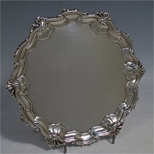 An Antique Georgian Sterling Silver salver, having a plain burnished ground, an applied shell and scroll border, and sitting on three cast hoof feet. Made by James Wilks of London in 1752. The dimensions of this fine hand-made antique silver salver are diameter 19 cms (7.55 inches), and it weighs approx. 262g (8.5 troy ounces).   