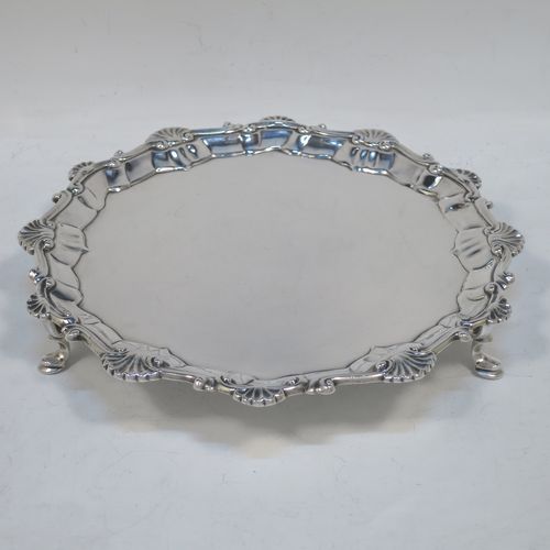 A very elegant Antique Georgian Sterling Silver salver, having a plain burnished ground, an applied shell and scroll border, and sitting on three cast hoof feet. Made by Ebenezer Coker of London in 1767. The dimensions of this fine hand-made antique silver salver are diameter 21 cms (8.5 inches), and it weighs approx. 310g (10 troy ounces).  