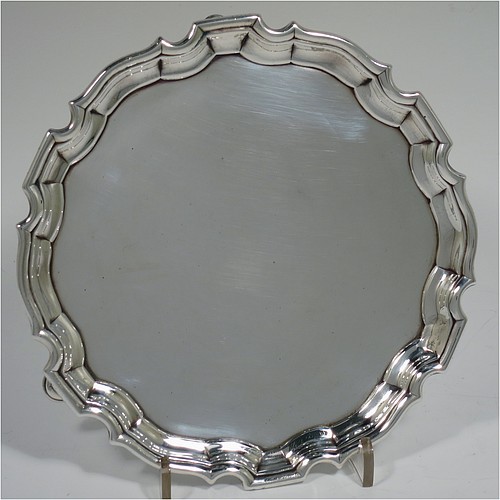 An Antique Georgian Sterling Silver George II round salver, having a plain burnished ground, an applied Chippendale border, and sitting on three cast hoof feet. Made by George Hindmarsh of London in 1736. The dimensions of this fine hand-made antique silver salver are diameter 15.5 cms (6 inches), and it weighs approx. 209g (6.7 troy ounces).    