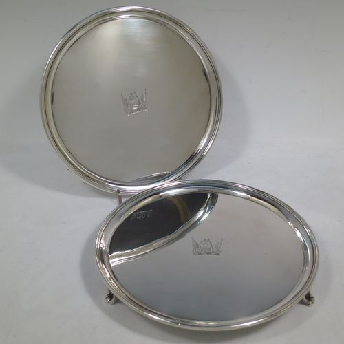 A very handsome Antique Georgian Sterling Silver pair of salvers, having applied reeded borders, plain grounds with hand-engraved central crests, and sitting on three cast reeded flange feet. Made by John Schofiled of London in 1784. The dimensions of these fine hand-made antique silver pair of salvers are diameter 19 cms (7.5 inches), and they weigh a total of approx. 682g (22 troy ounces).   