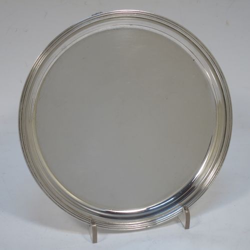 A very elegant Georgian style Sterling Silver salver, having a plain ground, with an applied reeded border, and all sitting on three cast flanged feet. Made by Edward Barnard of London in 1936. The dimensions of this fine hand-made silver salver are diameter 15 cms (6 inches), and it weighs approx. 187g (6 troy ounces).  