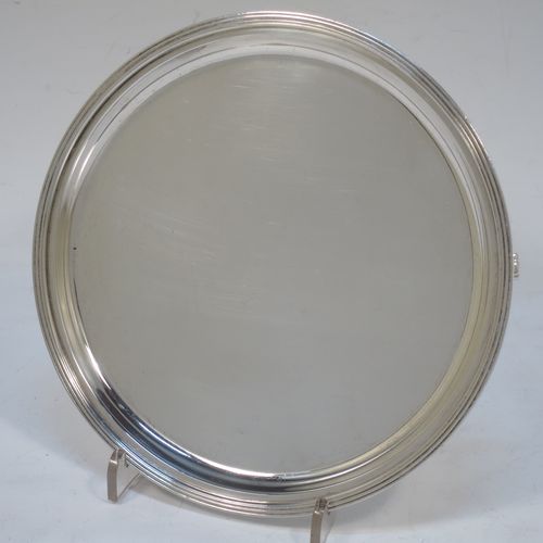 A very elegant Georgian style Sterling Silver salver, having a plain ground, with an applied reeded border, and all sitting on three cast flanged feet. Made by Edward Barnard of London in 1936. The dimensions of this fine hand-made silver salver are diameter 15 cms (6 inches), and it weighs approx. 187g (6 troy ounces).  