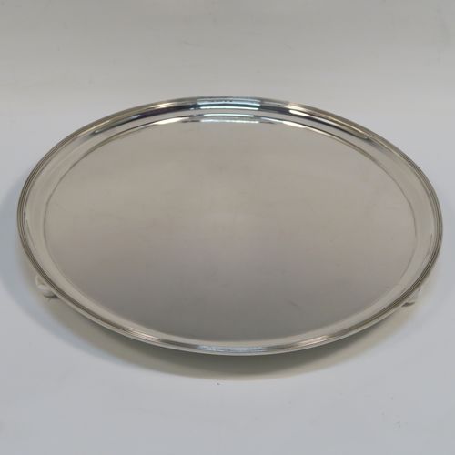 A heavy and very elegant Georgian style Antique Sterling Silver salver, having a plain ground, with an applied reeded border, and all sitting on three cast ball feet. This handsome antique silver salver was made by Herbert Lambert of London in 1912. The dimensions of this fine hand-made silver salver are diameter 23 cms (9 inches), and it weighs approx. 574g (18.5 troy ounces).  