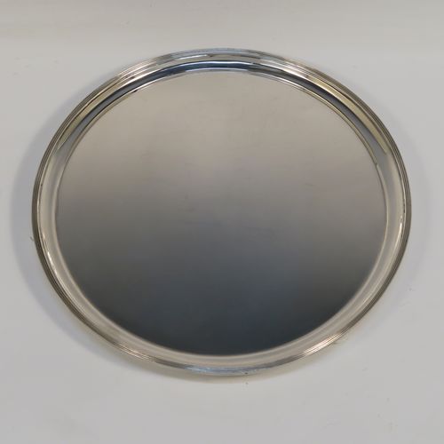 A heavy and very elegant Georgian style Antique Sterling Silver salver, having a plain ground, with an applied reeded border, and all sitting on three cast ball feet. This handsome antique silver salver was made by Herbert Lambert of London in 1912. The dimensions of this fine hand-made silver salver are diameter 23 cms (9 inches), and it weighs approx. 574g (18.5 troy ounces).  